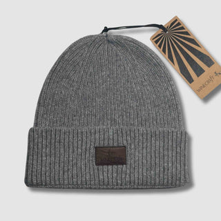 Produktfoto der grauen Merino Beanie Damen & Herren – flach hingelegt mit Hangtag, aus hochwertiger, weicher Merinowolle, perfekt für kalte Tage.