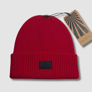 Produktfoto der roten Merino Beanie Damen & Herren – flach hingelegt mit Hangtag, aus hochwertiger, weicher Merinowolle, perfekt für kalte Tage.