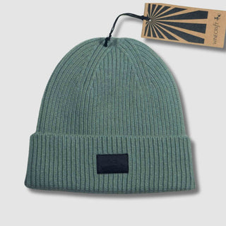 Produktfoto der türkis Merino Beanie Damen & Herren – flach hingelegt mit Hangtag, aus hochwertiger, weicher Merinowolle, perfekt für kalte Tage.