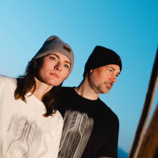Mann und Frau tragen Merino Beanies Damen & Herren – stilvolle, nachhaltige Mützen aus weicher Merinowolle für gemütliche Wintertage.